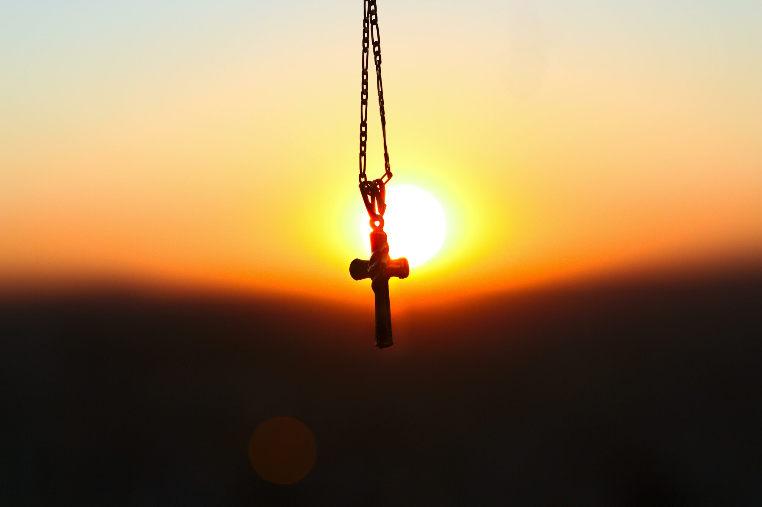 Kette mit einem Kreuz in Sonnenuntergangslicht